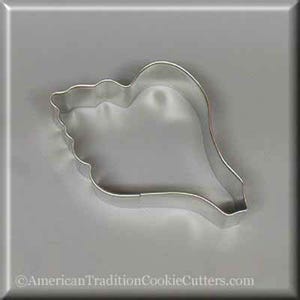 May include: A stainless steel seashell cookie cutter. The cutter is in the shape of a conch shell, with a detailed edge. The image is on a gray background. The website address "AmericanTraditionCookieCutters.com" is at the bottom.
