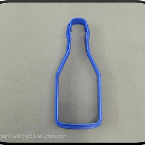 May include: Blue plastic cookie cutter shaped like a bottle.  The cookie cutter is designed to cut out the shape of a bottle.