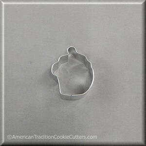 May include: A silver metal cookie cutter shaped like a cupcake with a single candle on top.