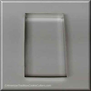 May include: A silver metal cookie cutter shaped like a rectangle. The cookie cutter is about 3 inches tall and 2 inches wide.