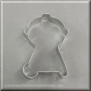 May include: A silver metal cookie cutter shaped like a barbecue. The cookie cutter is on a grey background.