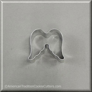 May include: A silver metal cookie cutter shaped like a pair of angel wings.