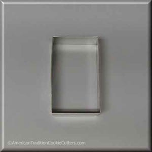 May include: A silver metal cookie cutter shaped like a rectangle. The cutter is on a gray background.