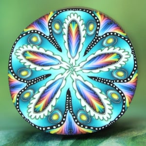 May include: A round, colorful decorative object with a floral design. The object features a turquoise background with a symmetrical pattern of rainbow-colored petals and yellow accents. The edges are outlined in black and white.