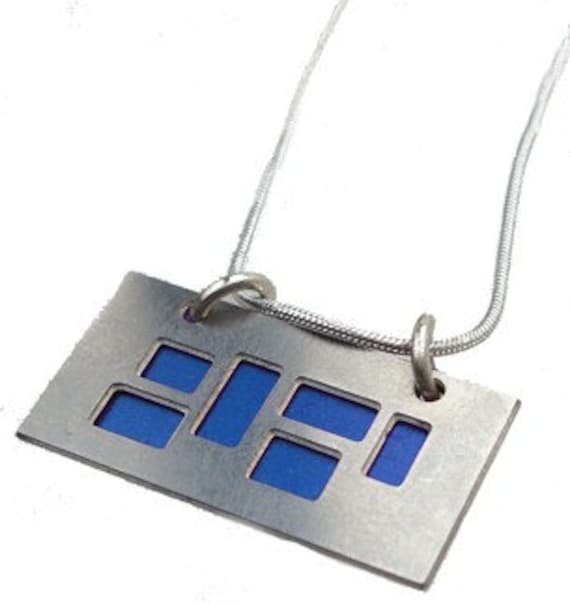 silver pendant with blue and Black cutouts