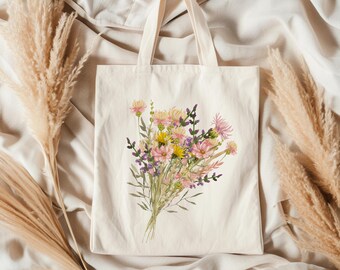 May include: A white tote bag with a floral design. The flowers are pink, yellow, and purple. The bag has a long handle.