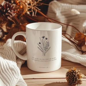 May include: White ceramic mug with a black floral design and the text "Come to me, all you who are weary and burdened, and I will give you rest | Matthew 11:28 |"