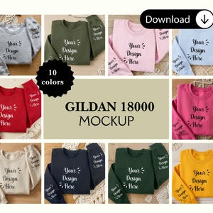Puede incluir: Una maqueta con diez sudaderas Gildan 18000 de diferentes colores. Cada sudadera muestra el texto "Your Design Here" en la parte delantera y en la manga. Los colores incluyen gris, verde oliva, rosa, azul claro, rojo, beige, azul marino, verde oscuro, fucsia y amarillo.