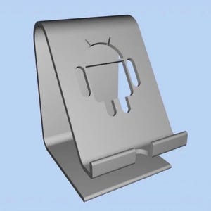 Puede incluir: Un soporte para teléfono de color plateado con un logotipo de Android recortado. El soporte tiene una parte trasera curvada y un pequeño borde en la parte inferior para sostener el teléfono. El diseño es simple y moderno.