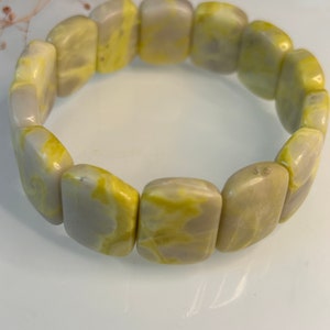 Könnte beinhalten: Ein Armband aus hellgrünen und grauen Steinperlen. Die Perlen sind rechteckig und haben ein marmoriertes Muster.