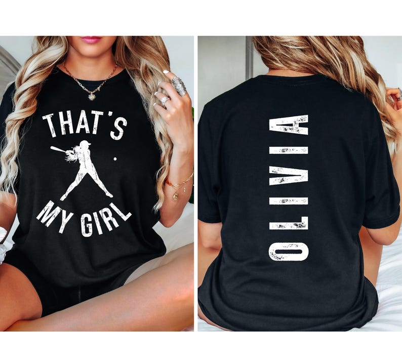May include: Black t-shirt with white text that says "That's My Girl" and a graphic of a female baseball player. The back of the shirt has white text that says "Olivia".