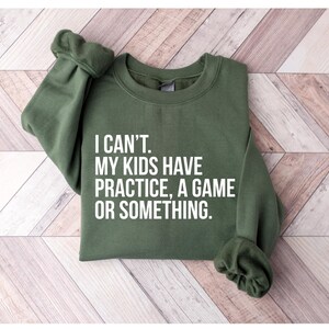 May include: Green sweatshirt with the text "I can't. My kids have practice, a game or something."