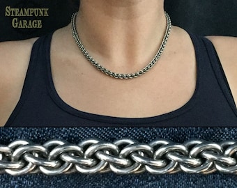May include: A silver chain necklace with a braided design. The chain is thick and has a polished finish.