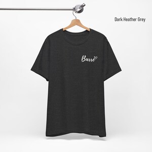 May include: Dark heather grey t-shirt with the word "Barre" and a heart on the front.