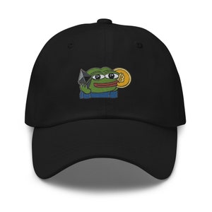 May include: Black baseball cap with an embroidered image of a green frog holding a black and silver pyramid and a gold coin with a Bitcoin symbol.