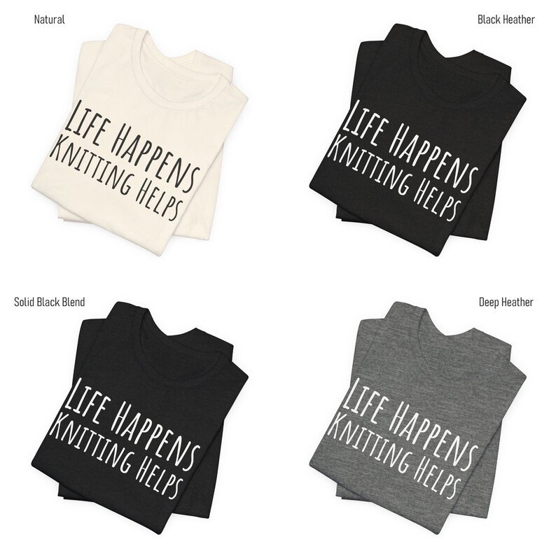 May include: Four folded t-shirts in different colors: natural, black heather, solid black blend, and deep heather. Each shirt features the text "LIFE HAPPENS KNITTING HELPS" in white.