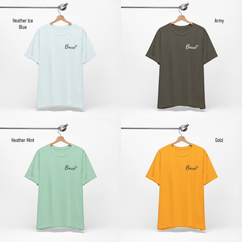 May include: Four t-shirts hanging on hangers, each in a different color: heather ice blue, army, heather mint, and gold. Each shirt has the word "Barre" printed on the front in black cursive.