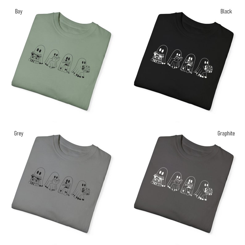 May include: Four white outline ghosts wearing hats and holding stacks of books on a t-shirt. The t-shirt is available in four colors: bay, black, grey, and graphite.