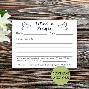 May include: A white card with the text "Lifted in Prayer" and space to write a name, date, and prayer requests. The card features dove illustrations and the text "Cast all your cares on Him for He cares for you - 1 Peter 5:7".