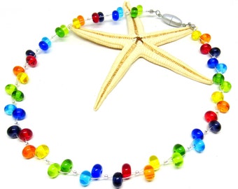 May include: A rainbow colored glass bead necklace with a silver clasp. The necklace is laid out on a white surface with a starfish.