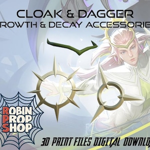 Może przedstawiać: Obraz z akcesoriami z tekstem "CLOAK & DAGGER GROWTH & DECAY ACCESSORIES". Obraz zawiera zielony obiekt w kształcie strzałki i dwa złote, okrągłe obiekty z ostrymi krawędziami. Widoczne jest r&oacute;wnież logo "ROBIN PROP SHOP".