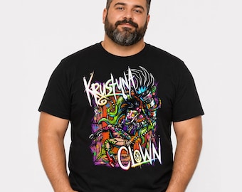Può includere: Una t-shirt nera a maniche corte con una vivace stampa grafica multicolore di un clown con capelli verdi che suona la chitarra. Il testo Krustyna Clown è stampato in un carattere bianco stilizzato sulla zona del petto.