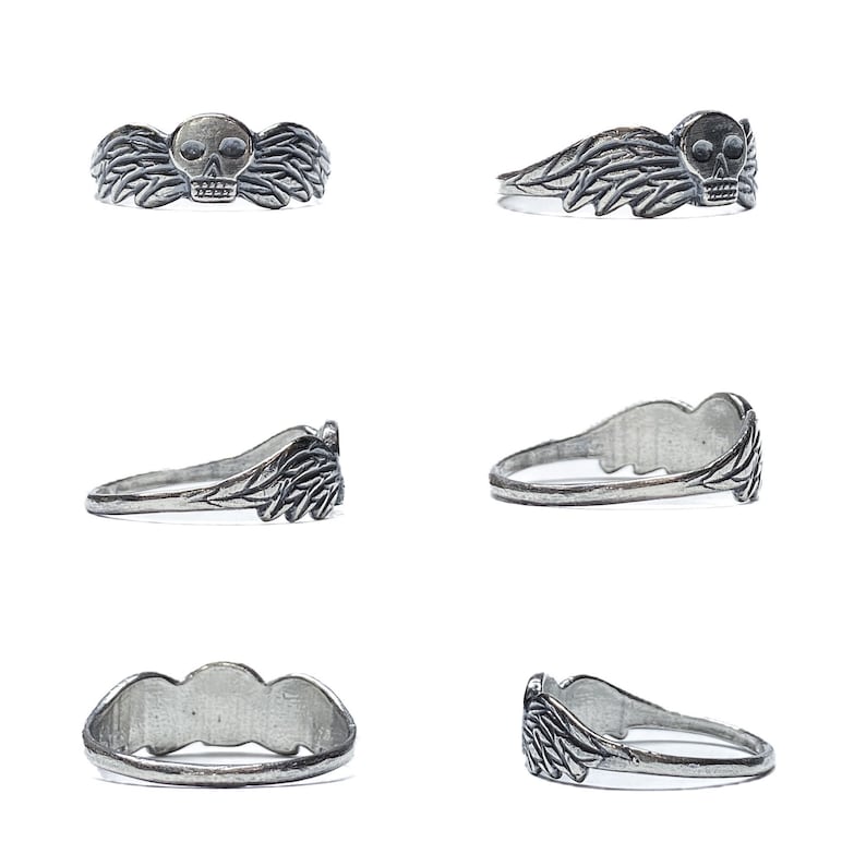 May include: A silver ring with a skull and wings design. The ring is shown from multiple angles.
