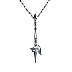 May include: A silver necklace with a pendant shaped like a medieval halberd. The pendant has a long, pointed blade and a small axe head.