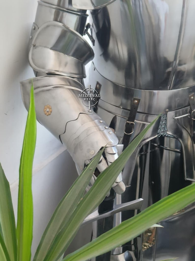 May include: A polished, silver-colored suit of armor, featuring articulated plates for the arms and torso. The armor has a reflective surface and is designed with overlapping segments. The image includes the text "MEDIEVAL RELIC".