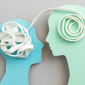 May include: A blue silhouette of a head and a light green silhouette of a head facing each other. A white ribbon emerges from the blue head, forming a tangled knot, and extends to the light green head, where it forms a neat, circular spiral.