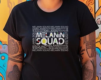 May include: Black t-shirt with the text "MELANIN SQUAD" in a square design. The text is in white, with colorful accents. The shirt is short-sleeved and made of a soft material.