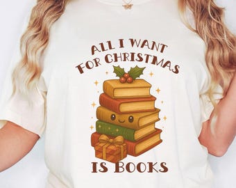 May include: Cream-colored t-shirt with the text "ALL I WANT FOR CHRISTMAS IS BOOKS" in brown. The graphic features a stack of books with a holly sprig and a wrapped gift. The books are in shades of brown, green, and orange.