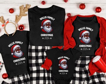 May include: Black t-shirts featuring a graphic of a Black Santa Claus and the text "WILLIS FAMILY CHRISTMAS 2024". The shirts are displayed against a black and white checked background.