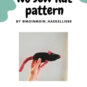 Könnte beinhalten: Ein schwarzes und pinkfarbenes Häkel-Rattenspielzeug. Die Ratte hat einen langen Schwanz und wird von einer Hand gehalten. Das Bild enthält den Text "No sew Rat pattern BY @moinmoin_haekkelliebe".