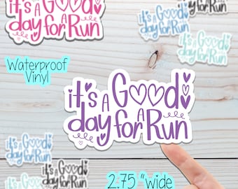 May include: Waterproof vinyl sticker with the text "It's a Good day for a Run" in purple lettering with pink hearts. The sticker is 2.75 inches wide.