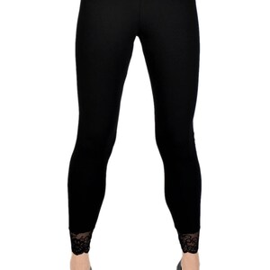May include: Black leggings with a black lace waistband and lace trim at the bottom of the legs.