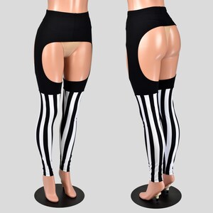 May include: Black high-waisted leggings featuring large circular cutouts at the upper thighs and hips. The lower portion of the legs displays a vertical black and white striped pattern. The garment is shown from both the front and back views.