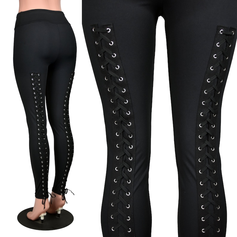 Op de afbeelding: Zwarte leggings met een vetersluiting aan de zijkanten. De veters zijn zwart en hebben zilveren oogjes.