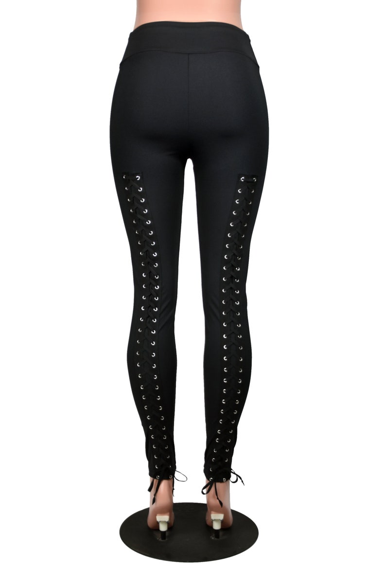 Op de afbeelding: Zwarte leggings met een vetersluiting aan de achterkant van de benen.
