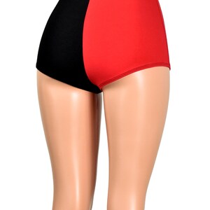 May include: High-waisted shorts featuring a split-color design with a solid black panel on the left side and a solid red panel on the right side. The garment has a smooth, fitted silhouette that covers the upper thighs and sits at the waist.