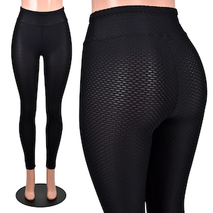 May include: Black leggings with a textured, honeycomb-like pattern. The leggings are fitted and have a high waist.