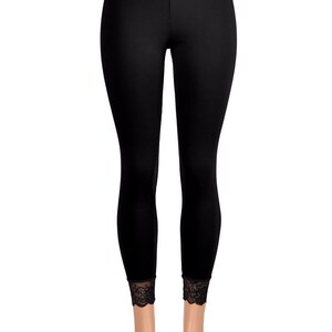 May include: Black leggings with a black lace waistband and lace trim at the bottom of the legs.