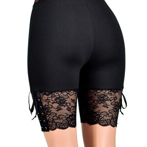 May include: Black shorts with lace trim and tie details. The shorts are made of a stretchy fabric and have a high waist.