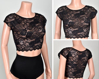 May include: Black lace crop top with short sleeves. The top is sheer and has a scalloped hem.