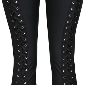 Op de afbeelding: Zwarte leggings met een veterdetail aan de zijkanten. De veters zijn zwart en de oogjes zijn zilver.
