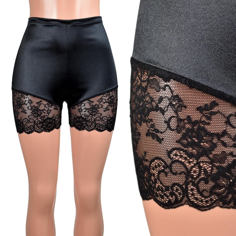 May include: High-waisted black shorts featuring a smooth satin-like finish on the upper portion and wide panels of intricate black floral lace along the lower leg openings. The garment has a fitted silhouette with a clean, straight waistband.