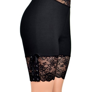 May include: Black shorts with lace trim and tie detail. The shorts are made of a stretchy fabric and have a comfortable fit.