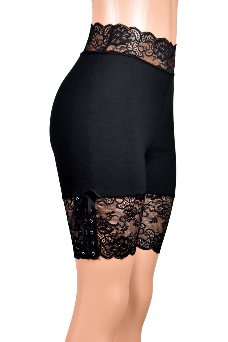 May include: Black shorts with lace trim and tie detail. The shorts are made of a stretchy fabric and have a comfortable fit.