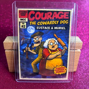 May include: A Courage the Cowardly Dog trading card, featuring Eustace and Muriel. The card has a red and yellow title with the text "COURAGE THE COWARDLY DOG". Eustace holds an axe, and Muriel holds a rolling pin. The card is in a protective sleeve.