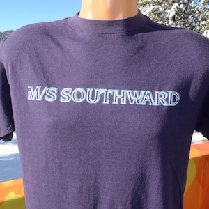 May include: A navy blue t-shirt with the text "M/S SOUTHWARD" printed in white with a blue outline.